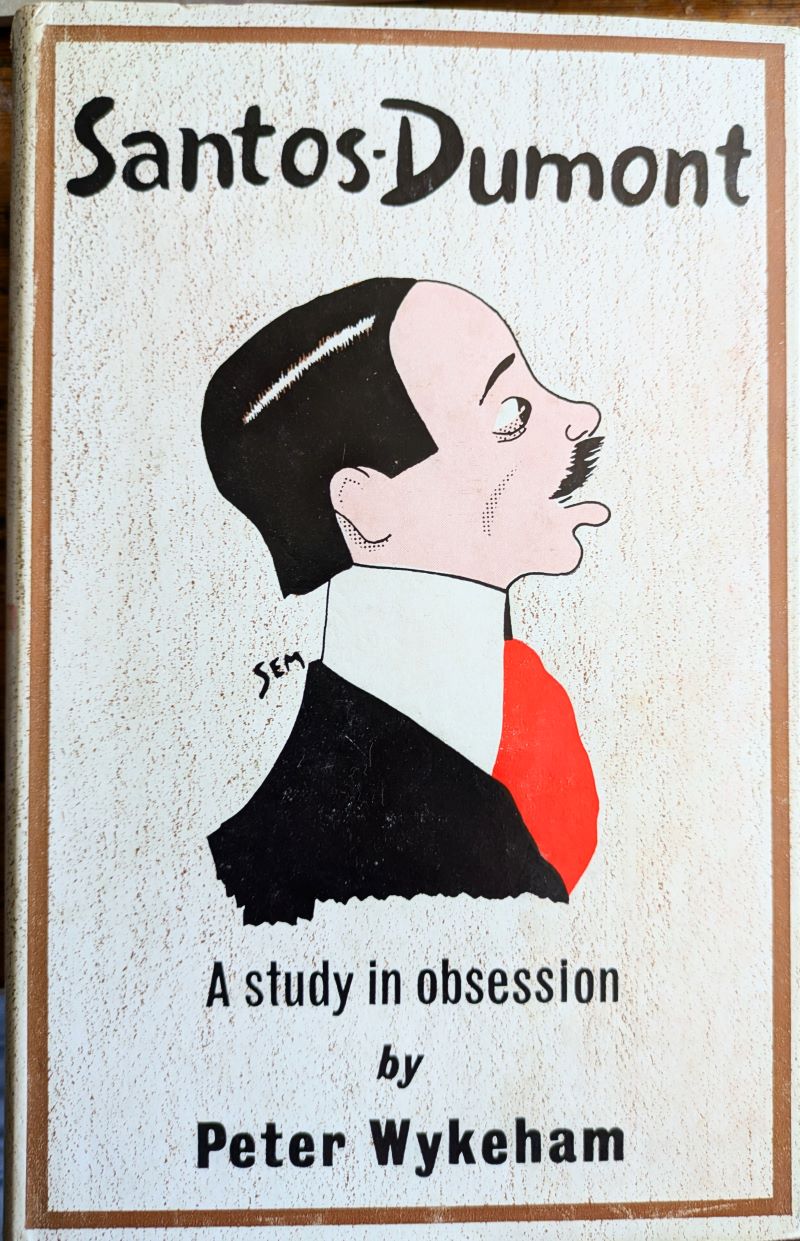Picture of colour pictorial book cover showing a cartoon being a side view of the head and shoulders of the ever-stylish Santos-Dumont wearing a high stiff collar and red cravat.